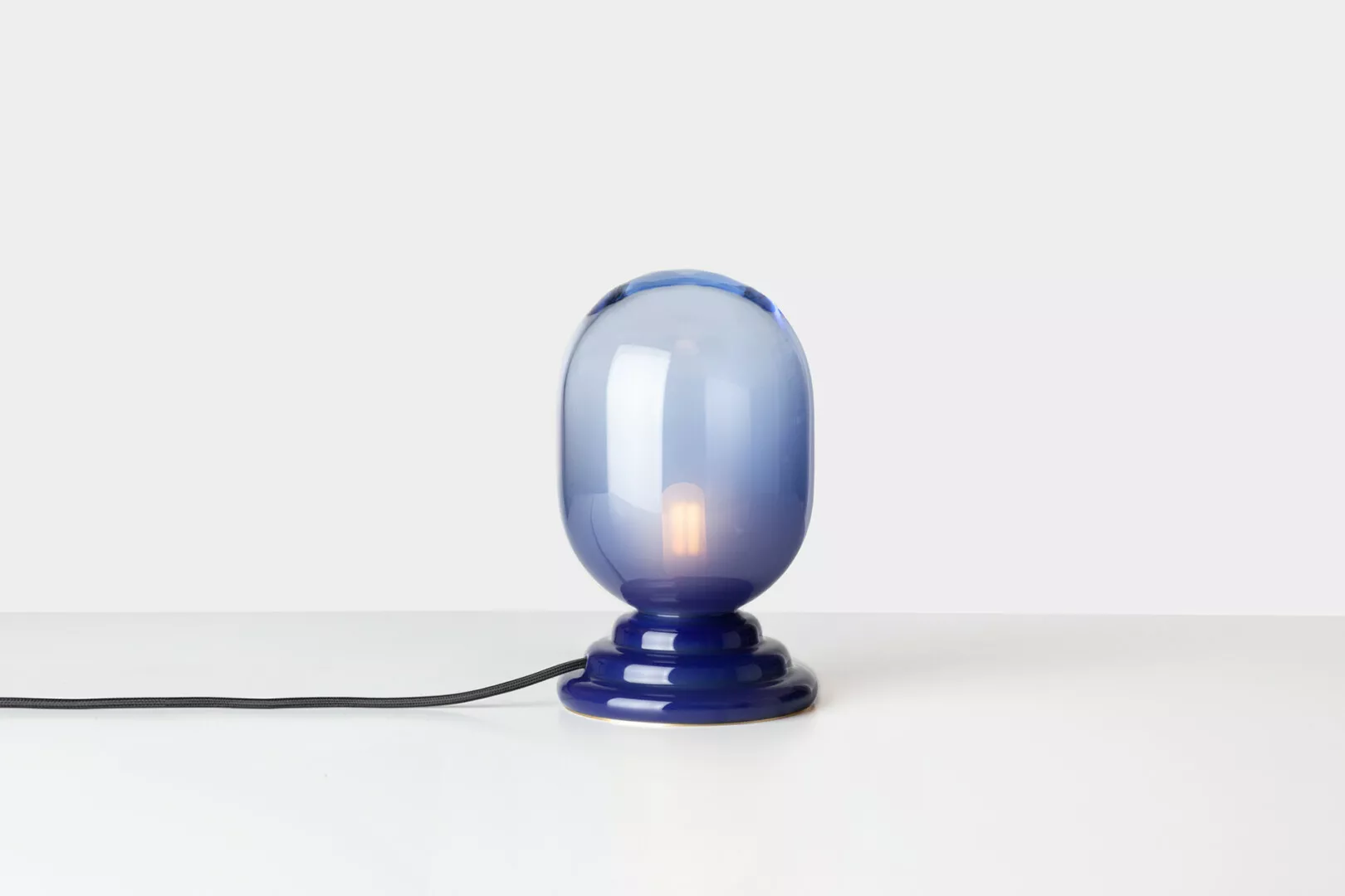 Blue glass table lamp on white background.
