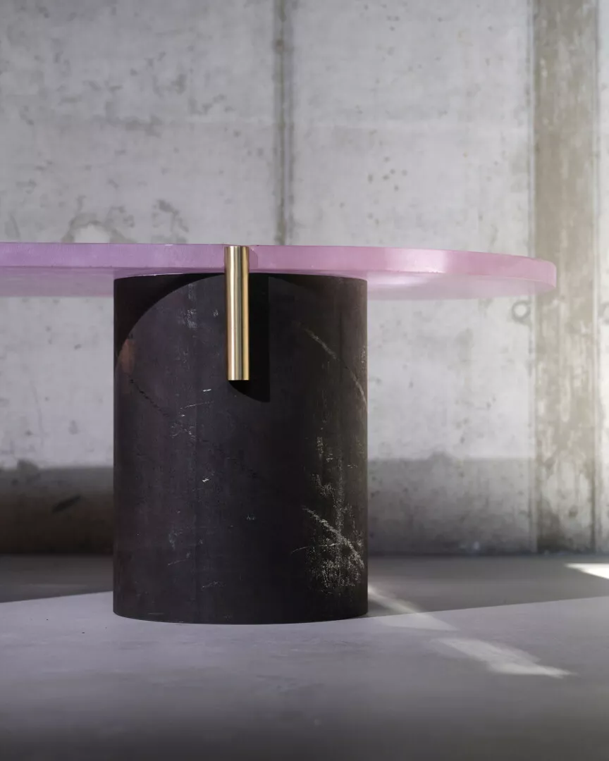 Modern pink marble table with cylindrical black base.