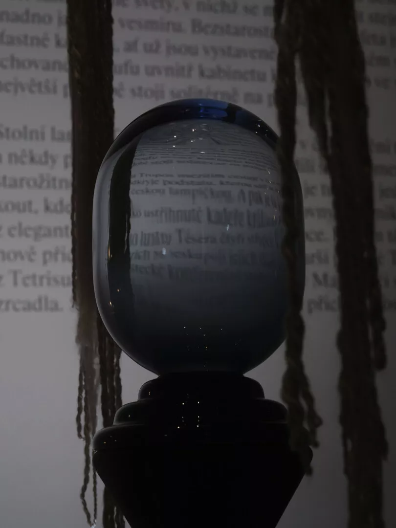 Crystal ball on stand with blurred text background.