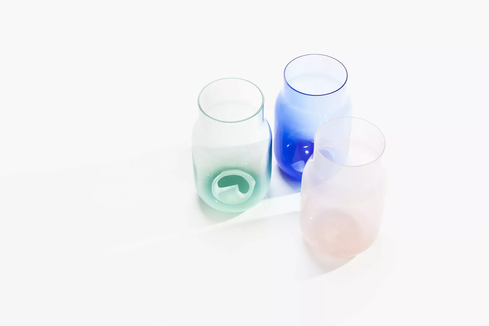 Colorful glass vases on white background.