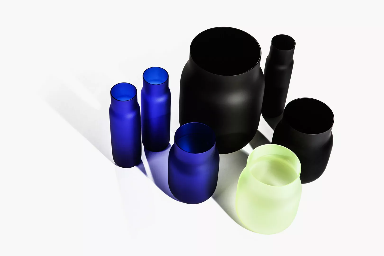 Colorful modern glass vases on white background.