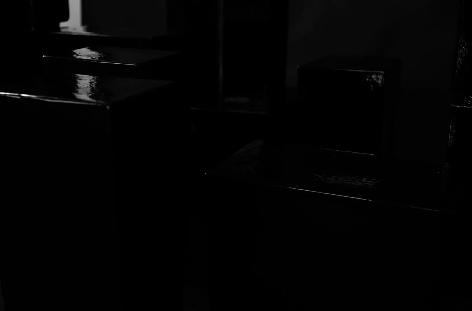 Monochrome image of wet, dark stairs at night.