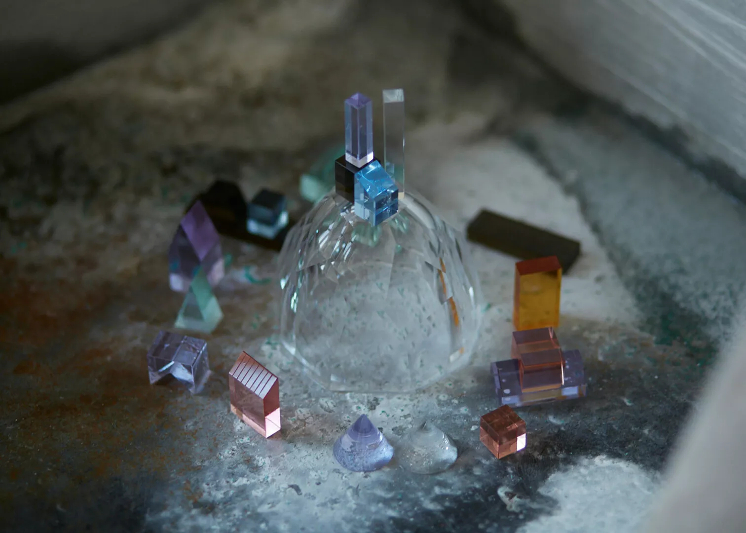 Colorful crystal sculptures on textured surface.