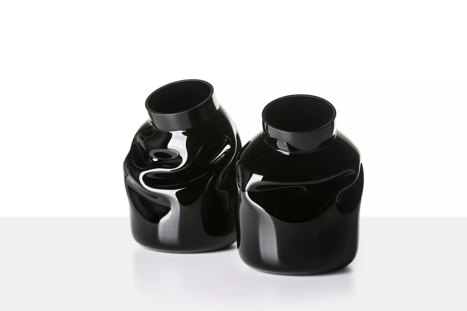Two glossy black ceramic vases on white background.