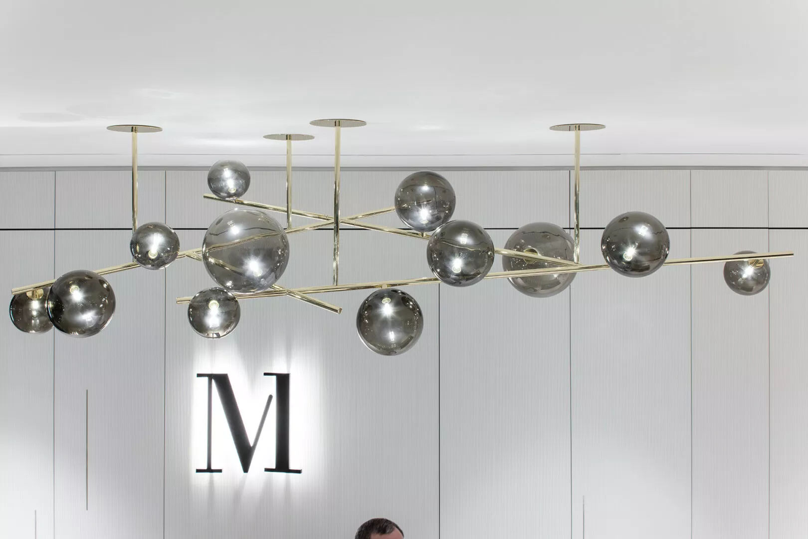 Modern spherical chandelier in elegant interior setting.