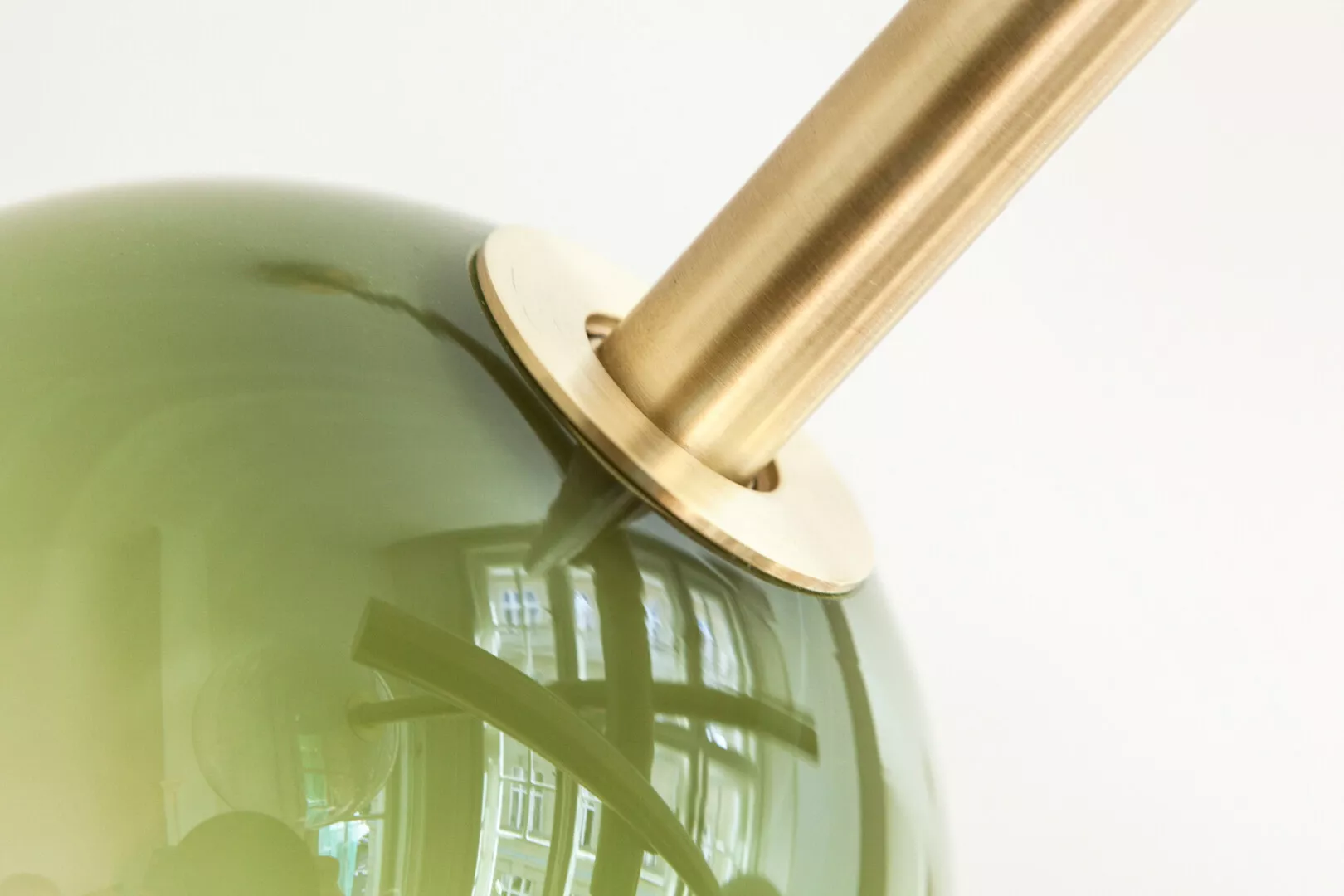Golden lamp reflecting distorted window image