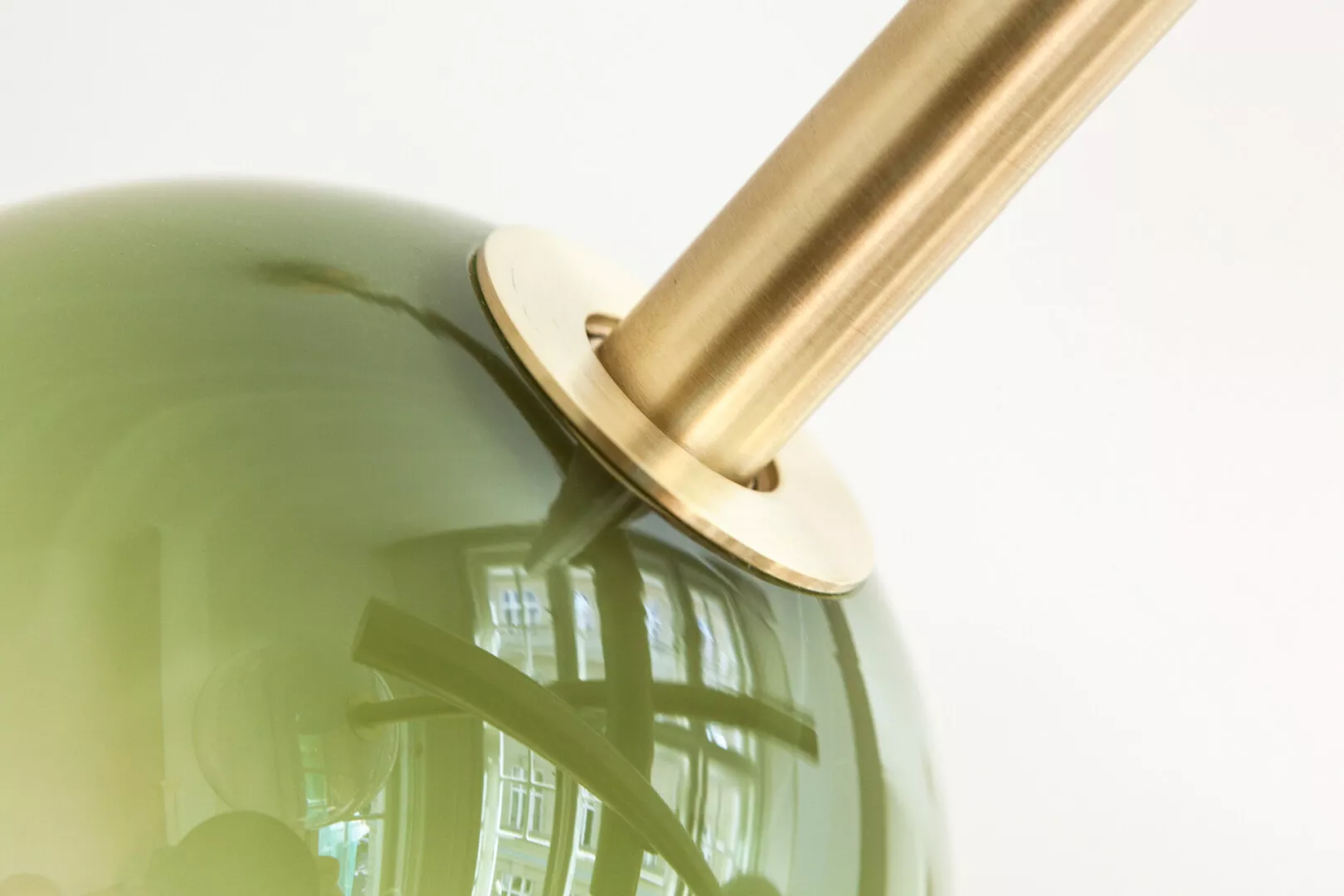 Close-up of golden lamp on green glass surface.