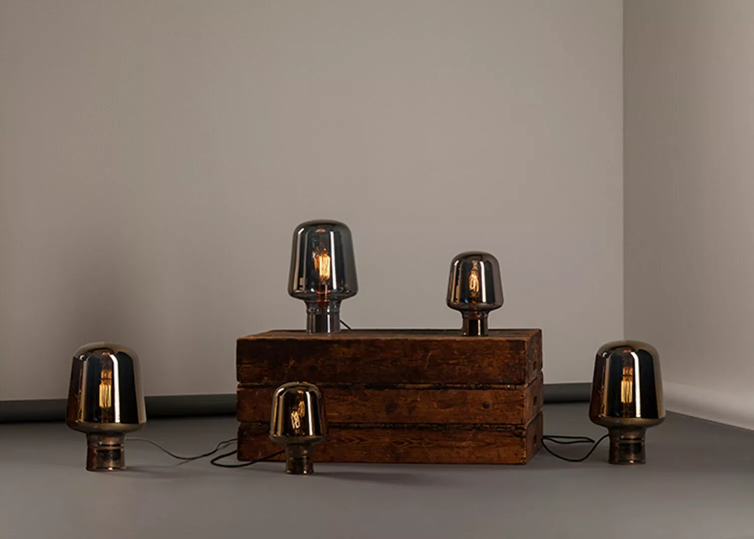 Vintage lamps on wooden box, minimalist interior lighting.