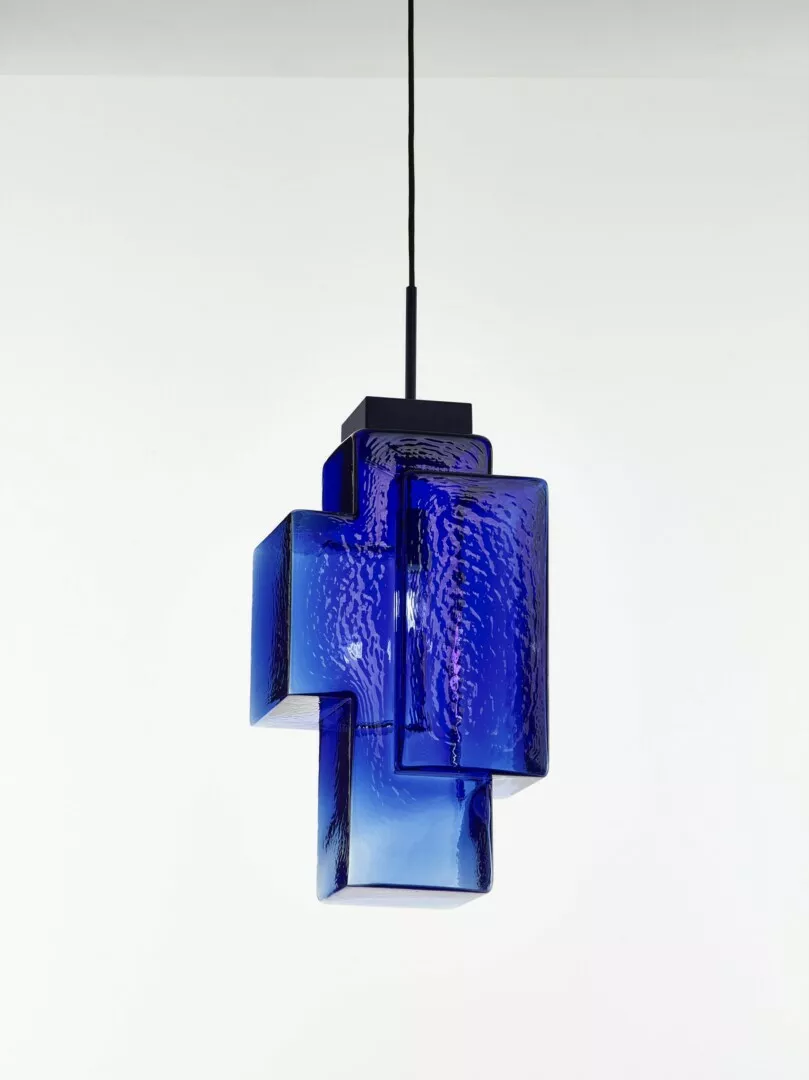 Blue textured glass pendant light against white background.