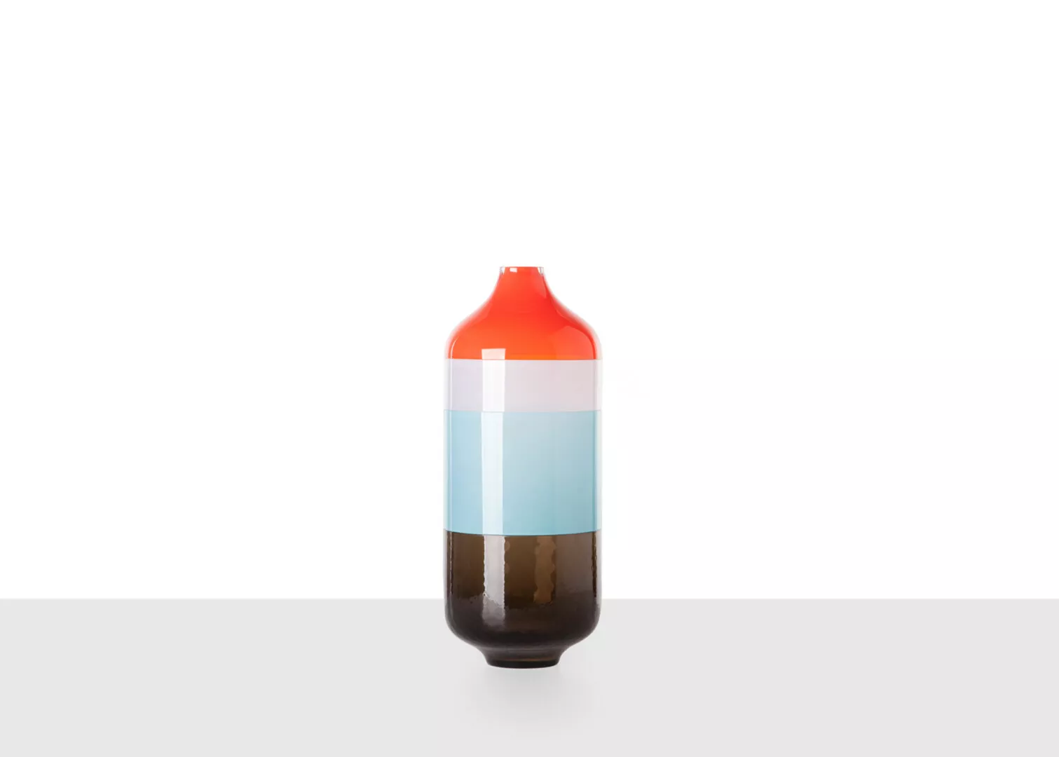 Half-full soda bottle with red cap on white background.