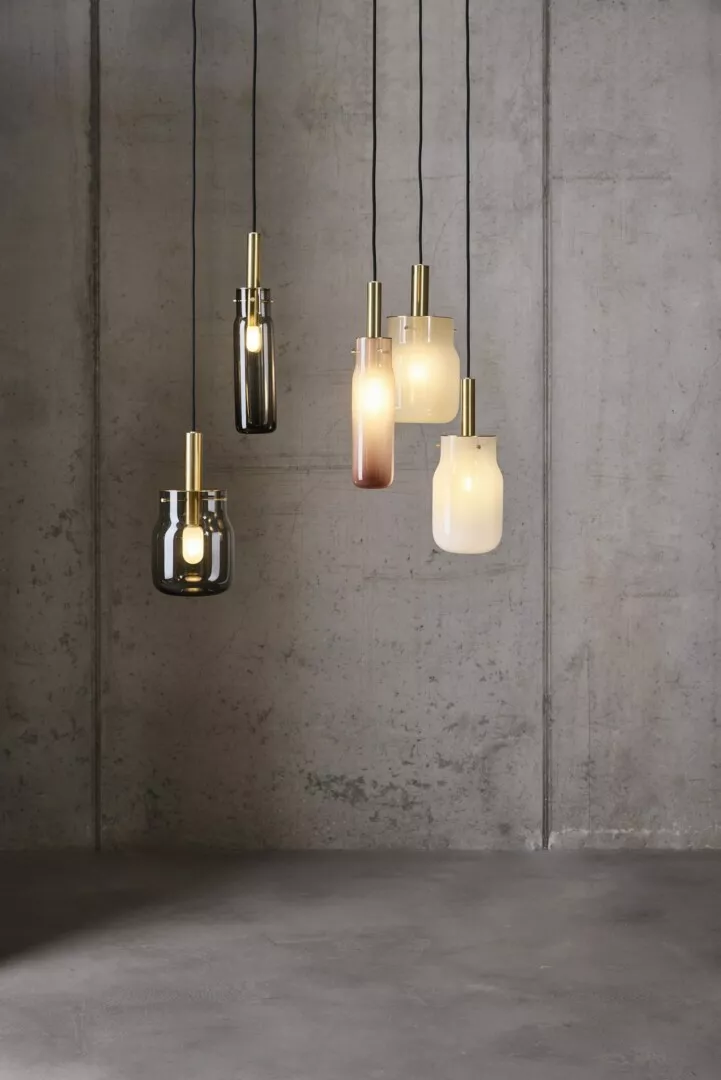 Modern pendant lights hanging against concrete wall.