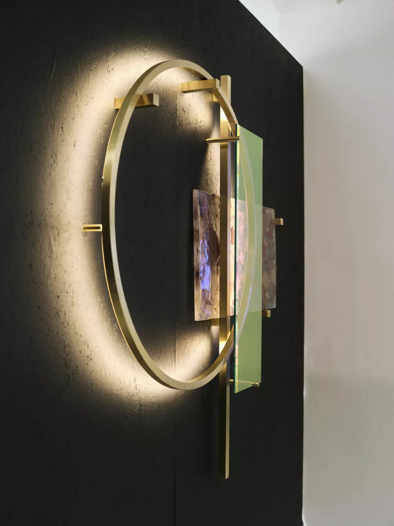 Modern circular wall sconce with artistic glass accents.