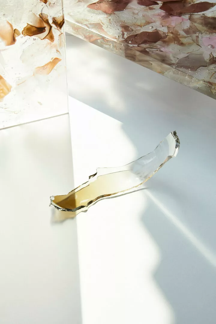 Broken glass shard on sunlit white surface.