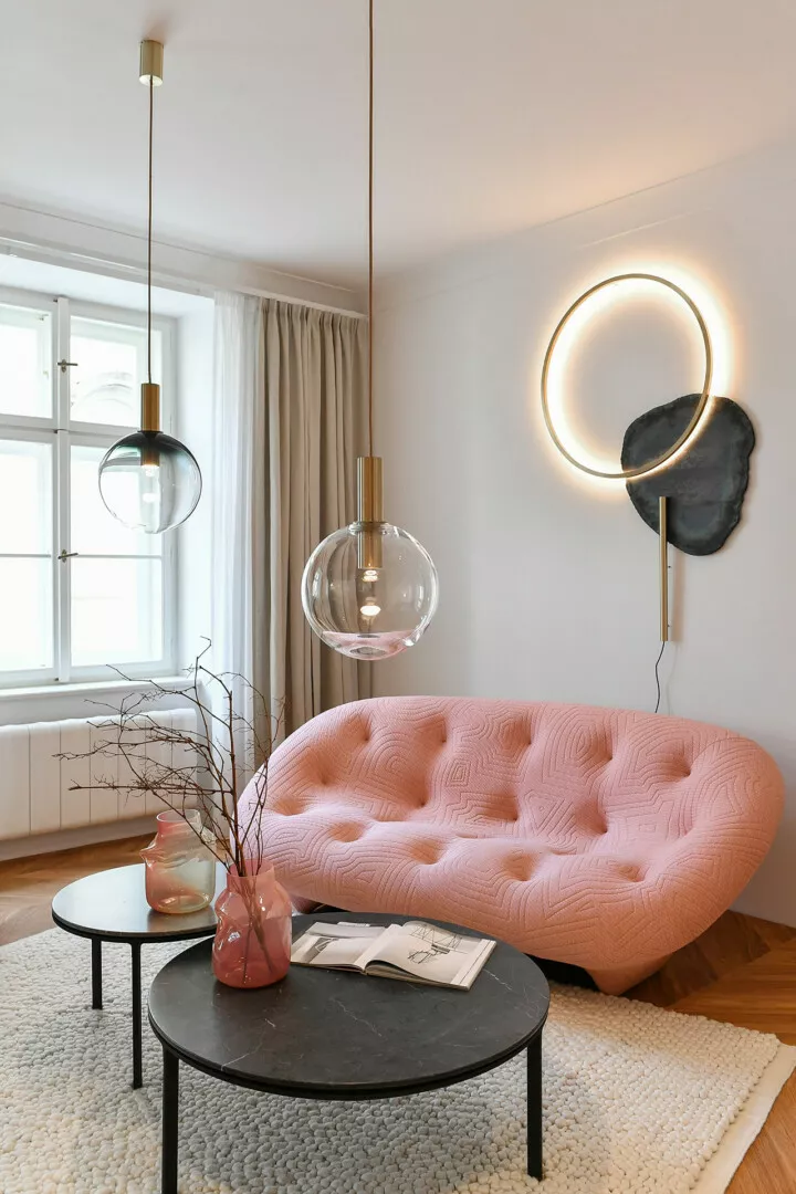 Modern living room with pink sofa and stylish lighting.