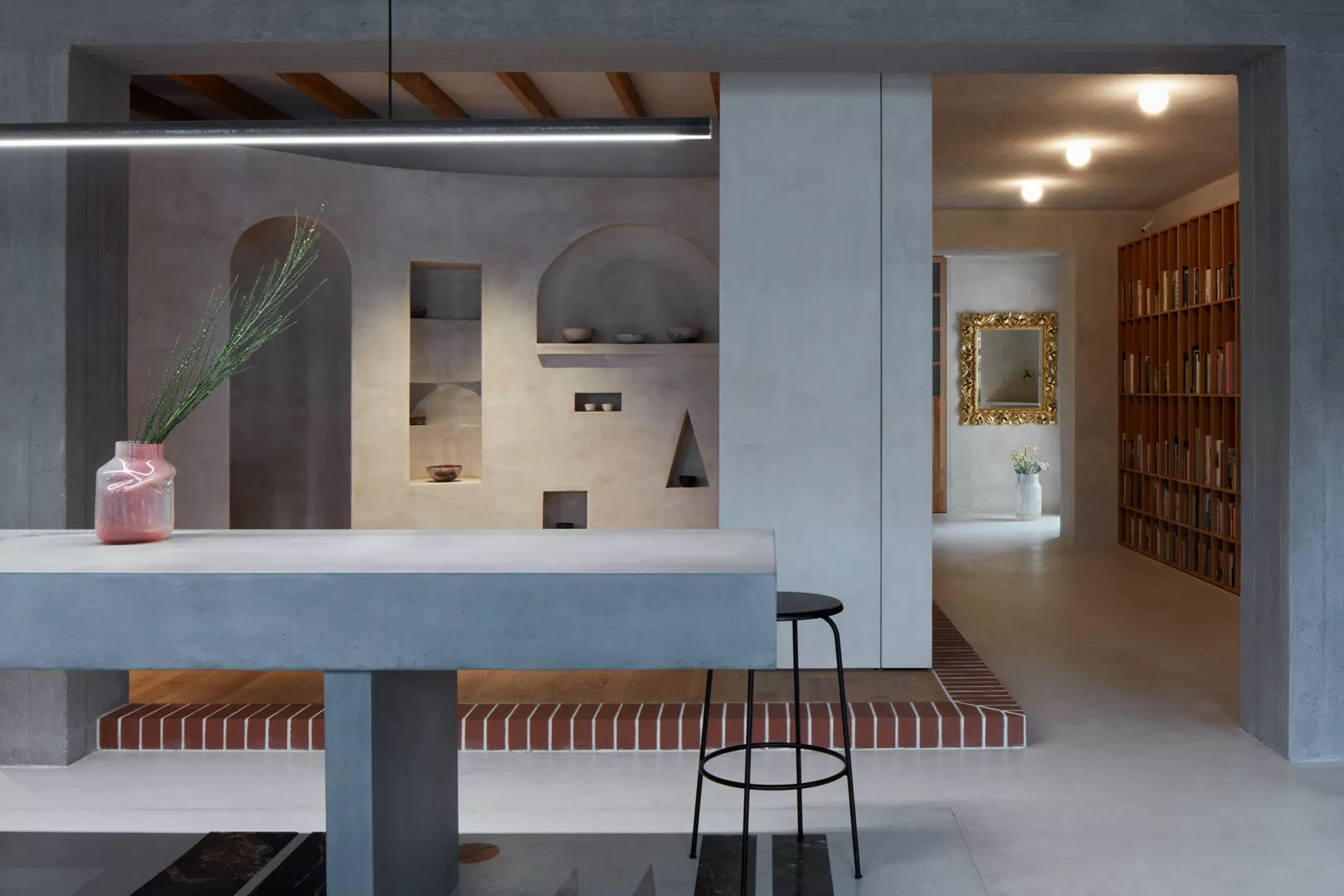 Modern interior design with concrete and bookshelf details.